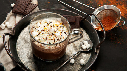Cacao with marshmallow and cacao powder in mug.