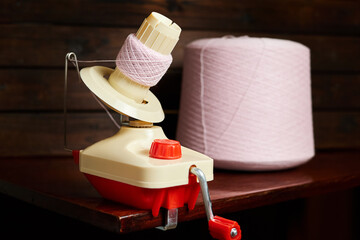 Mechanical yarn winder or reel while rewinding thread. Close-up, selective focus - obrazy, fototapety, plakaty