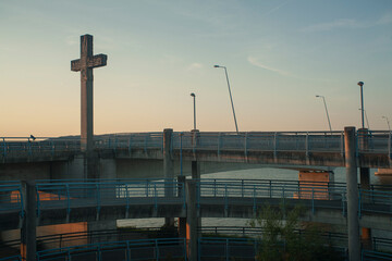 cruz católica de cemento en un puente 