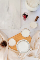 Milk drinks in clear jars and glass of milk on marble table background. Healthy drink concept. Top view and copy space. 