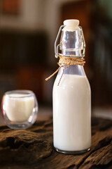 Milk in a bottle and glass of milk on wooden background.