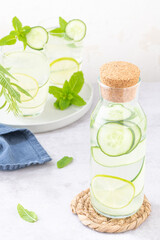 Fototapeta na wymiar Refreshing infused water with cucumber, mint and lime. Summer drink cocktail lemonade. Healthy drink and detox concept