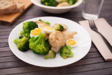 healthy appetizer of chicken pieces with broccoli and quail eggs in bowl for healthy lunch