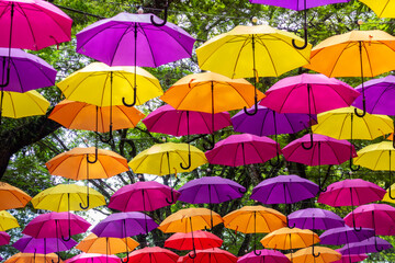 Fototapeta na wymiar Street decorated with colorful umbrellas, in Holambra, Sao Paulo, Brazil.. Runner of colorful umbrellas.