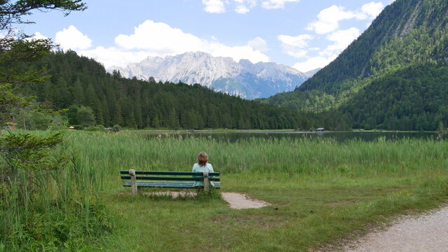 Wanderin genie&szlig;t den Anblick des tiefgr&uuml;nen Ferchensee mit den umliegenden Bergen