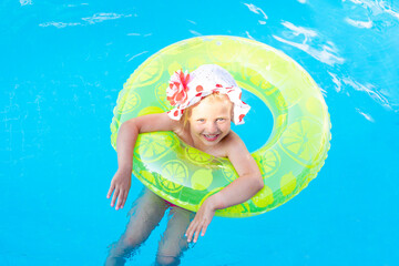 baby girl swims in the pool with an inflatable yellow circle in summer, the concept of travel and recreation and smiles in panama
