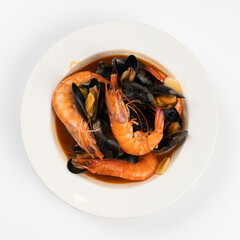 Schezwan Prawns in black bowl at dark slate background. Schezwan Prawns is indo-chinese cuisine curry dish with prawns or shrimps roasted in Schezwan Sauce.