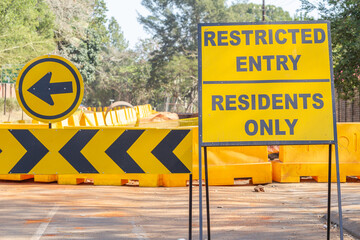 Construction warning street signs resident entry directions barricades close-up  photo.