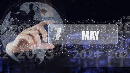 May 7th. Day 7 of month, Calendar date. Hand hold virtual screen card with calendar date.  Spring month, day of the year concept.