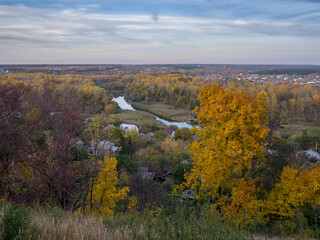 Fototapeta premium Autumn landscape with a view of the river valley, the village and the bridge. Ukraine, Chuguev