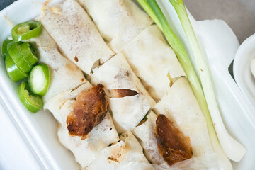 Asian fresh spring rolls and spring onion, topped with crab meat, green chili