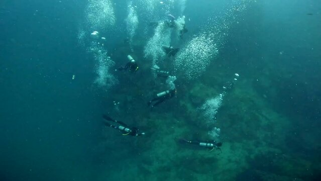 Under Water Film from Thailand -  A cluster of scuba divers filmed from above - air bubbles rising
