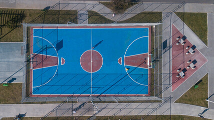 Outdoor sports frame in red and blue colors, top view with drone, of various sports, including basketball, volleyball and indoor soccer.