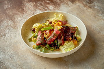 Salad with roastbeef and mango with hot sauce. Close-up, post-production noise. Selective focus