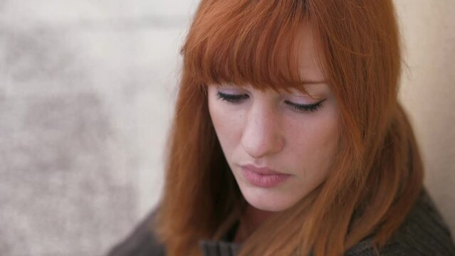 beautiful young woman staring at camera looks down in sad thoughts