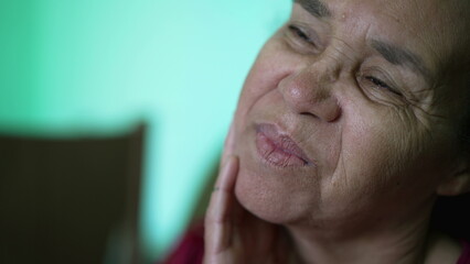 One thoughtful hispanic older woman closeup face. A pensive South American senior lady