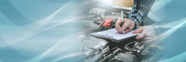 Car mechanic checking a car engine; panoramic banner