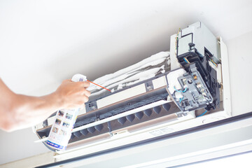 Mechanical man hand cleaning air condition in room with clean foam