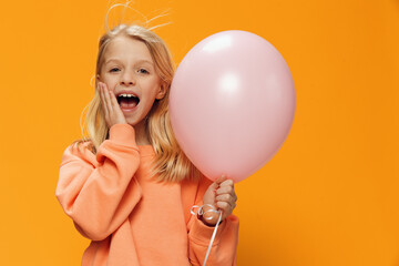 cute, happy girl stands with a pink balloon in her hand and screams loudly