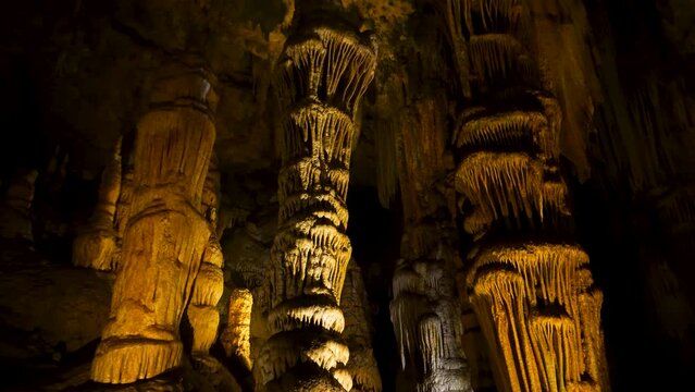 A tilt up shot of a cave with stalagmites and stalactites in Luray Cavern under a mountain in Shenandoah Valley
