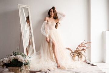 Woman wearing stylish champagne wedding dress at the professional photo studio