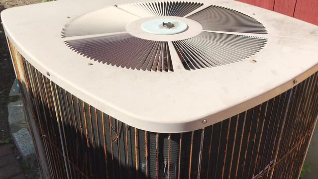 AC unit fan running outside house in summer