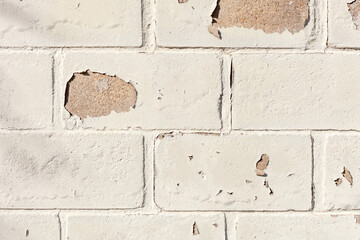 Brick wall with old and peeling paint.