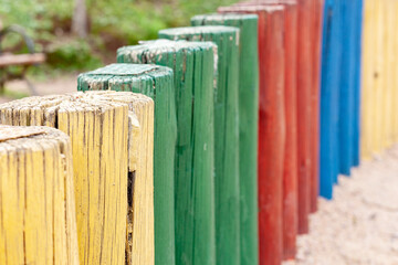 Fence with colored wooden logs.