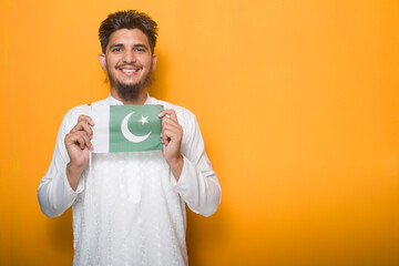 Young Boy in white dress holding Pakistan flag in hand, Independence day photography concept