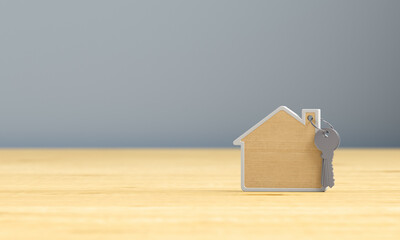 Small house with keys on a wooden surface. 3d render illustration.
