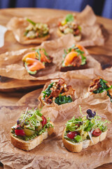Assorted bruschettas with various fillings. Appetizing bruschetta. Variety of small sandwiches or crostini. Traditional italian appetizer or snack, antipasto