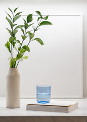 Colored transparent glass, frame, plant and book on table
