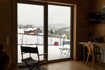 Breathtaking view from the window on snowy village in the mountains, cozy and comfortable...