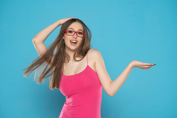 portrait of a young excited woman on a blue background, advertise some product