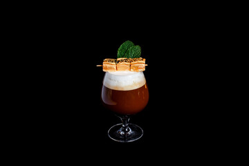 Espresso coffee glass with gold marshmallow up on black background.