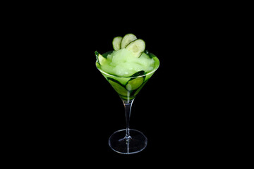 Green cocktail on the black background. With fresh cucumbers and sorbet.