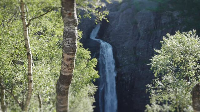 A view of the waterfall falling into a deep gorge. Pan backward, slow-motion.