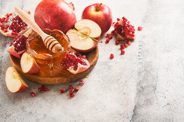 Rosh Hashanah. Pomegranate, apples and honey traditional products for celebration on rustic grey...