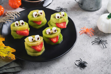 Spooky green kiwi monsters for Halloween. Healthy Fruit Halloween Treats. Halloween party kiwi,...