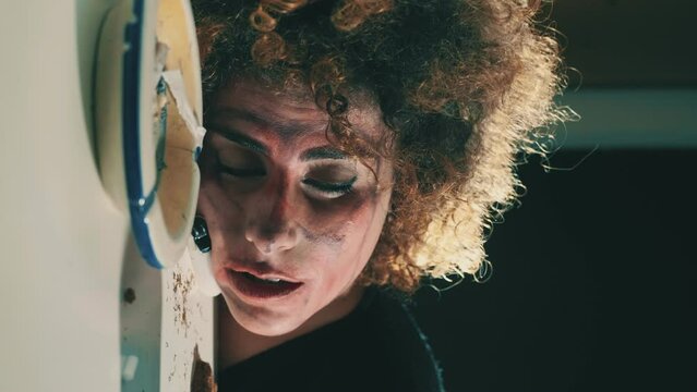 portrait of young woman brutalized by drugs with her head resting on the table
