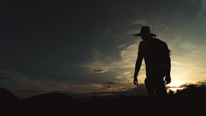 man traveler walking at sunset through the desert, silhouette of a man