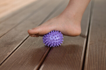 Myofascial relaxation of the muscles of the foot with a massage ball at home, close-up.
