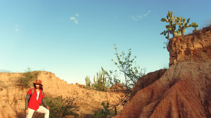 young man traveling with backpack in dry desert at sunset, enjoying the landscape in Colombia, tatacoa desert