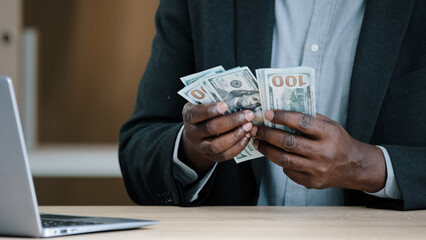 Close up African old male hands with money in office unrecognizable biracial success wealthy businessman holding dollars salary accounting savings budget cash financial income loan payment buying