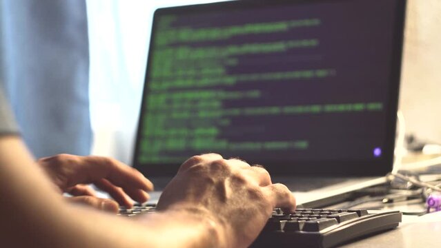 Male programmer. Human hands. Laptop on the table. Program code on the screen. Computational operations. Application programming. View code. Tester. IT-specialist. Close-up.
