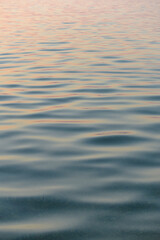 Calm sea waves with sunset reflection