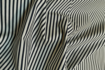 White fabric with black stripes. Crumpled or wavy fabric texture background. Abstract linen cloth soft waves. Natural yarn. Smooth elegant luxury cloth texture. Concept for banner or advertisement.