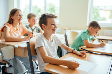 Elementary school children sitting in the classroom happy emotion and having fun. Happy diverse...