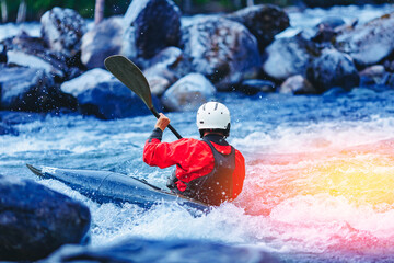 Extreme water sports, rafting on mountain river in kayak. Kayaker man strives for victory, boating...
