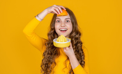 smiling teen girl hold orange and juicer on yellow background